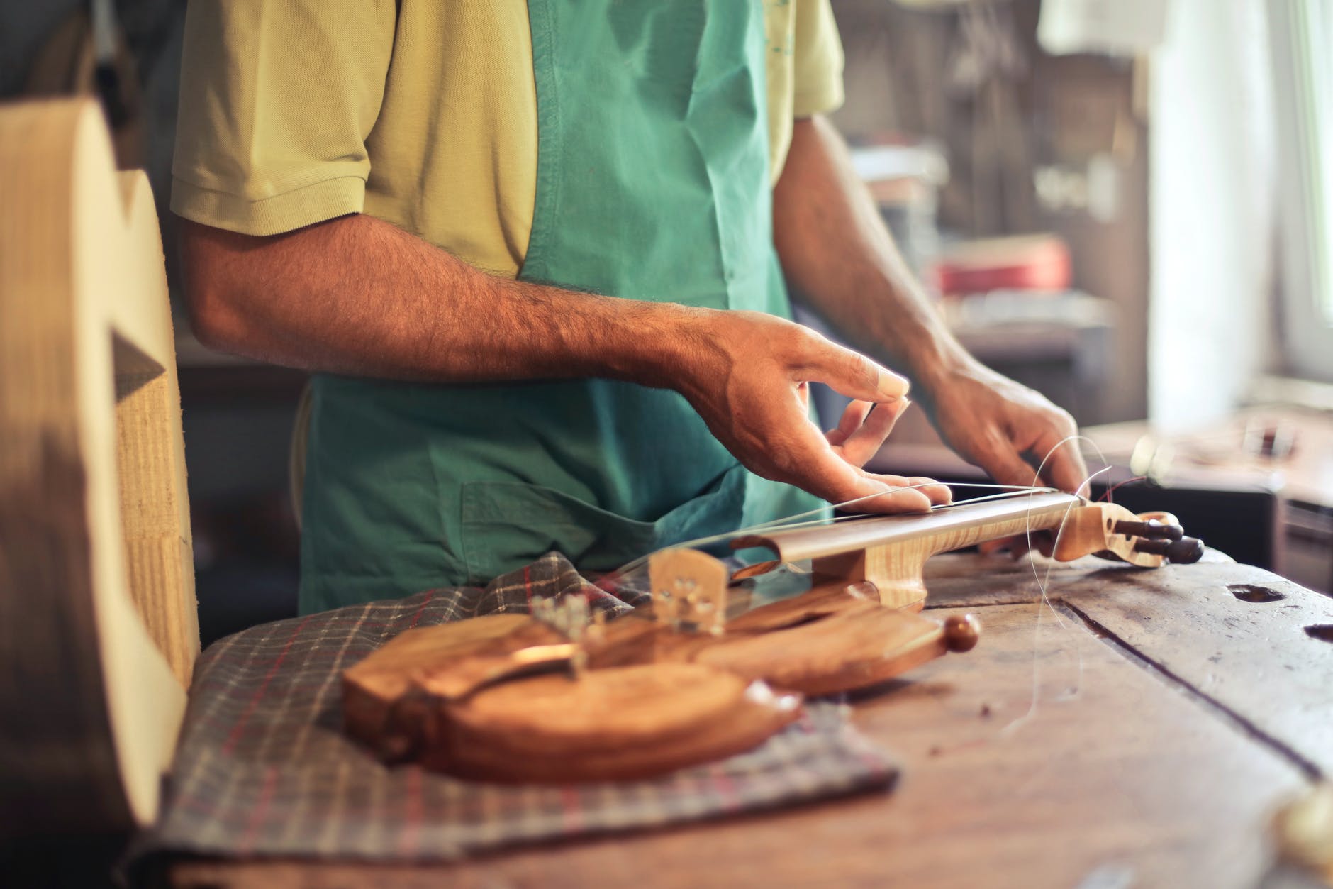 photo of person making a string instrument